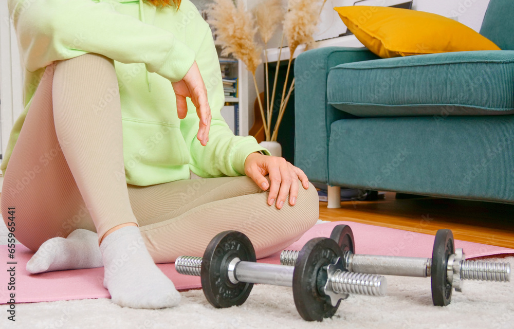 woman doing sports exercises with fitness ball and dumbbells at home
