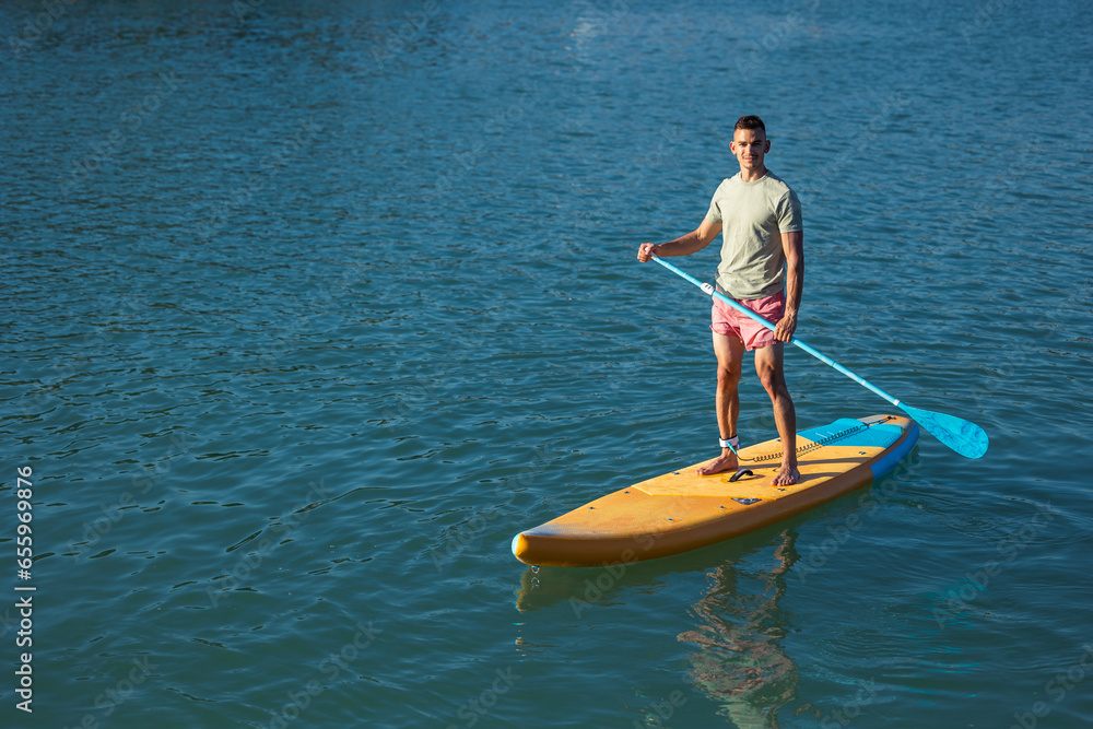 Fototapeta premium Man on sub board floating on ocean sea.