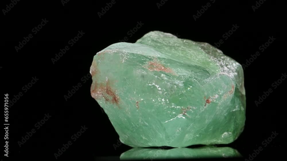 Green Calcite (calcium carbonate - CaCO3) sample rotating slowly against a black background. Green Calcite (calcium carbonate - CaCO3) sample rotating slowly against a black background.