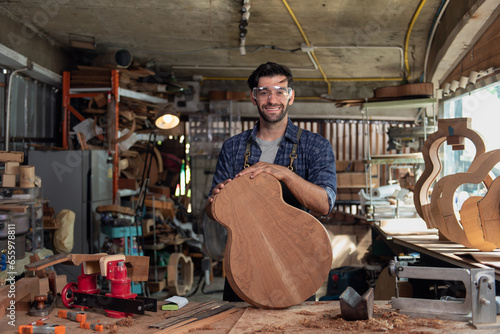 Portrait of guitar luthier small business owner in workroom