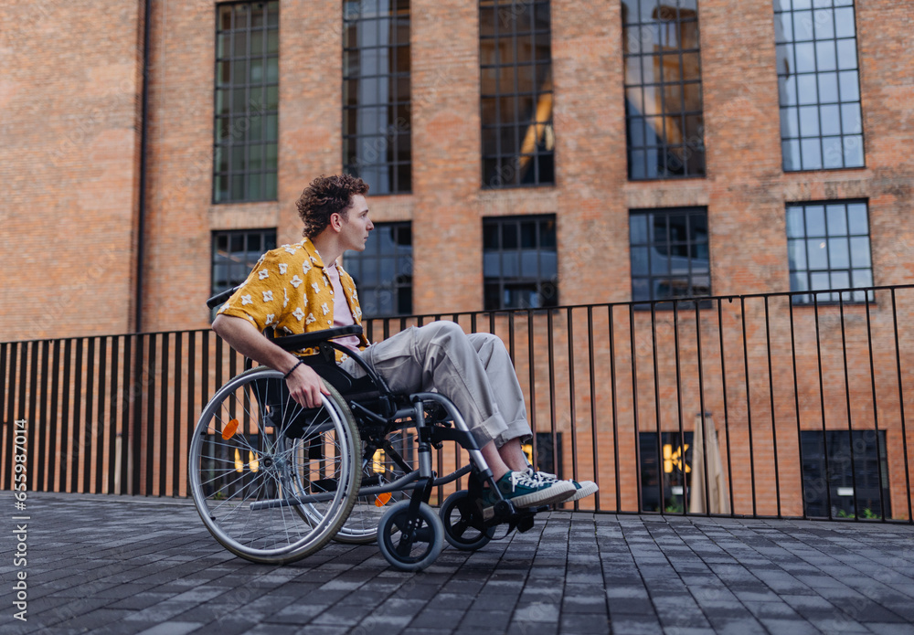 Obraz premium Gen Z boy in a wheelchair in the city.