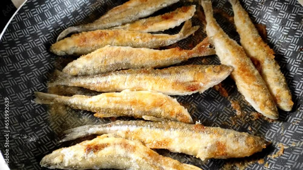 Small smelt fish is fried in a pan. Small smelt fish is fried in a pan.