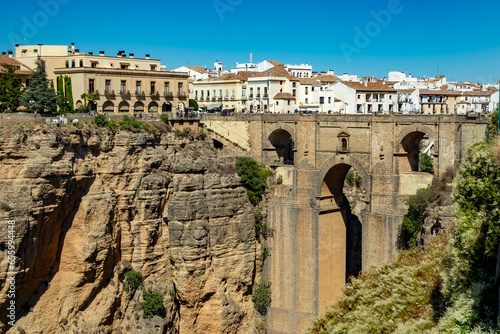 view of The Puente Nuevo bridge over a rocky canyon dividing the city of Ronda in Andalusia province.