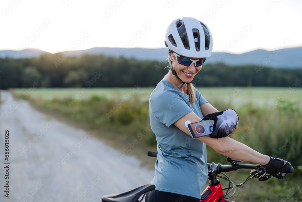 Diabetic cyclist connecting continuous glucose monitor with her