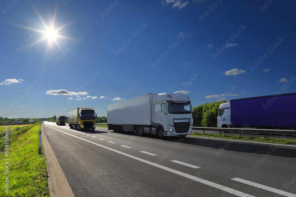 Cargo truck driving through landscape at sunset Cargo truck driving through landscape at sunset