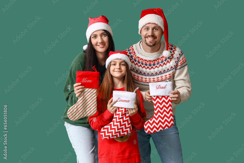 Happy family with Christmas socks on green background Happy family with Christmas socks on green background