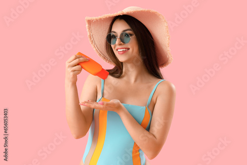 Young woman applying sunscr...