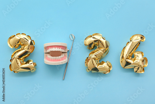 Jaw model with dental tool and figure 2024 on blue background