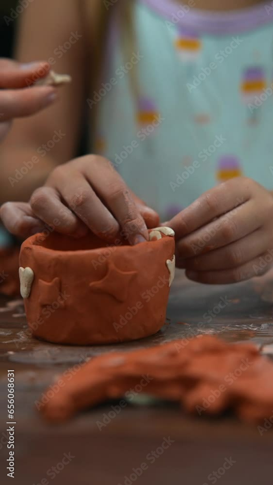 A kid is crafting clay figures on a wooden craft table. A kid is crafting clay figures on a wooden craft table.