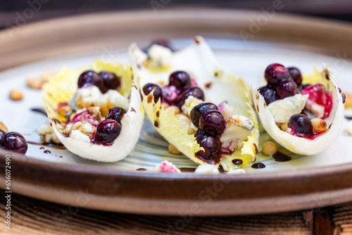 Belgium endive boats with huckleberries, nuts and cheese photo