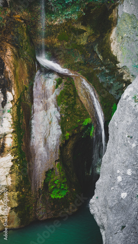 Little waterfall in a limenstone wall covered with vegetation photo