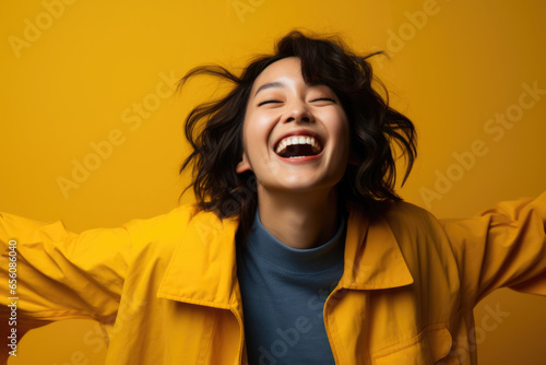 Joyful woman is seen laughing and raising her arms in excitement. Happiness and positive energy of moment. It can be used to depict joy, celebration, happiness, success, and freedom.