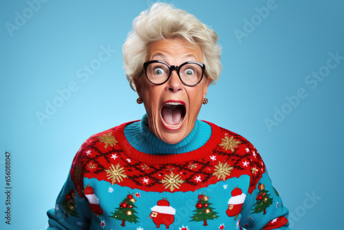 Isolated shouted senior woman wearing ugly christmas sweater.