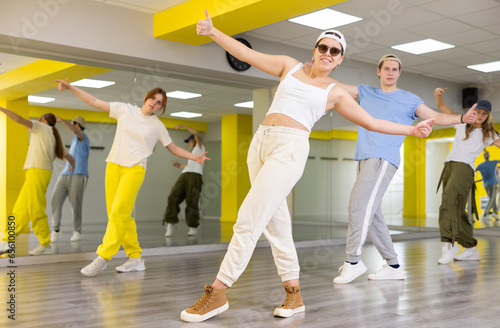 Smiling teenagers doing dance workout during group classes in fitness center