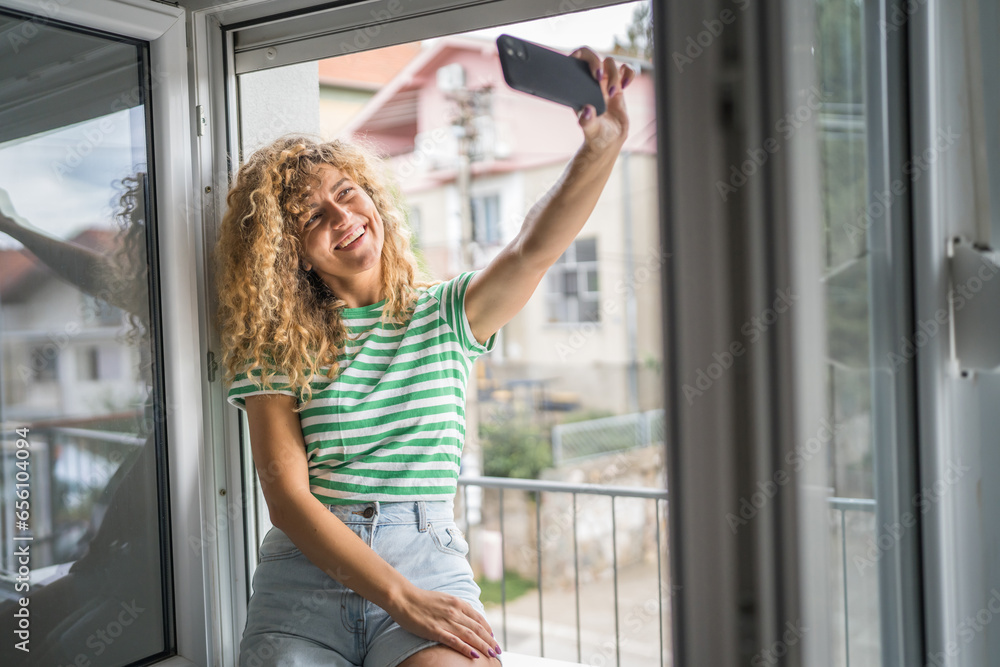 woman at the window use mobile phone take selfie photo self portrait
