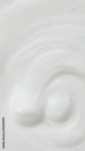 Falling blue berries in the yogurt on a rotation plate. Flat lay. Closeup