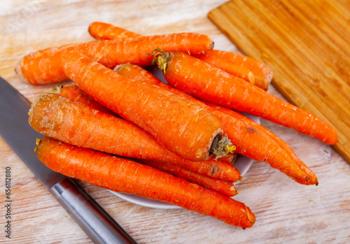 Fresh organic carrots on a wooden background on a table at a kitchen