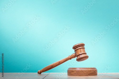 Retro auction or judge wooden gavel conceptual composition front aquamarine blue background. Symbols of justice. Vintage old style filtered photo