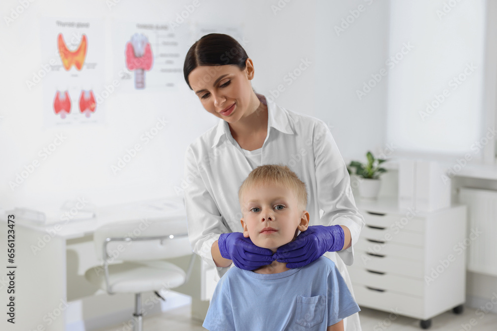 Endocrinologist examining boy's thyroid gland at hospital Endocrinologist examining boy's thyroid gland at hospital