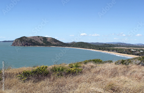 View of Kemp Beach with the ocean, sand, trees and grass from the Fan Rock Lookout at Yeppoon in Queensland, Australia