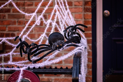 Scary big black spider on the white web, outdoor Halloween decoration