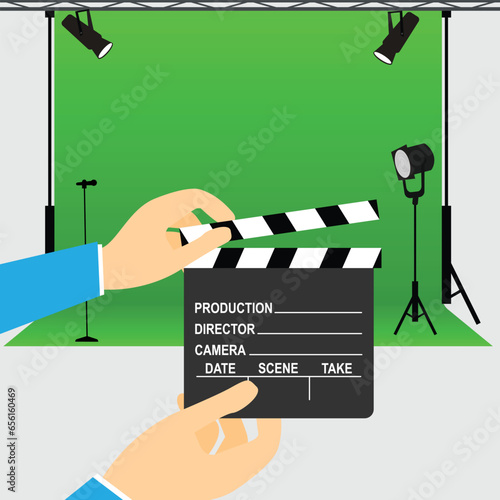 Hands holding a clapperboard in front of a movie studio