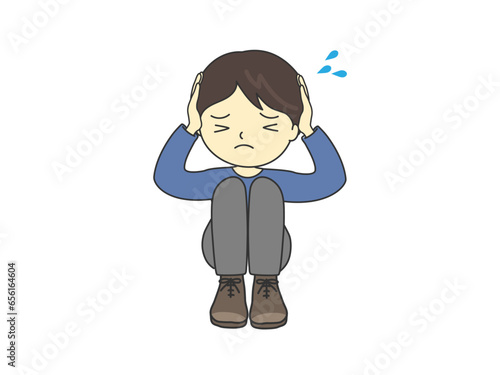 混乱しておびえて、頭を抱える男の子