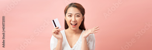 excited young asian woman holding credit card in hand  happy about sales and purchases  banner  panorama