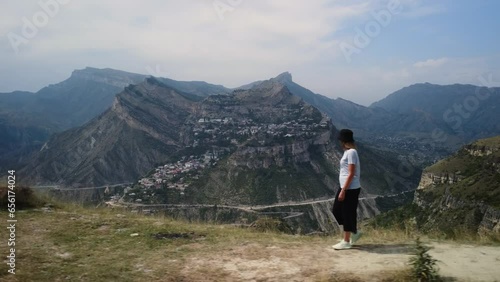 Aerial side view woman tourist walking hiking scenery caucasus mountain valley edge. Flying over deep canyon picturesque wild nature landscape Gunib village. Hike tourism travel wanderlust vacation 4