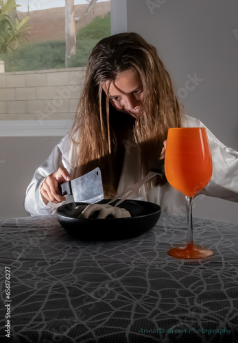 Foto Creepy girl prepares to eat human hand, vertical