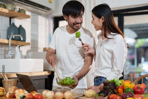 Couple making food or salad in the kitchen at home.