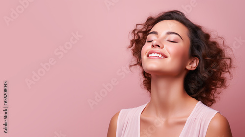 A woman closed eyes breathes relaxedly isolated on pastel background