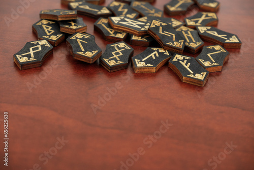 Black wooden runes on wooden table. Copy space for text.	