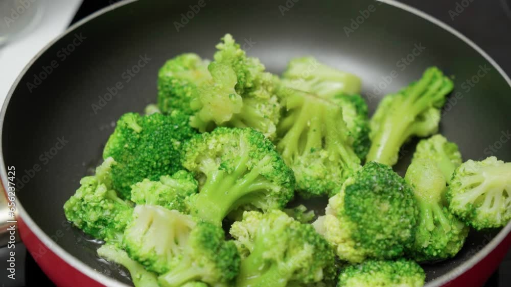 Cooking broccoli in a frying pan close-up. Homemade healthy, veggie food Cooking broccoli in a frying pan close-up. Homemade healthy, veggie food