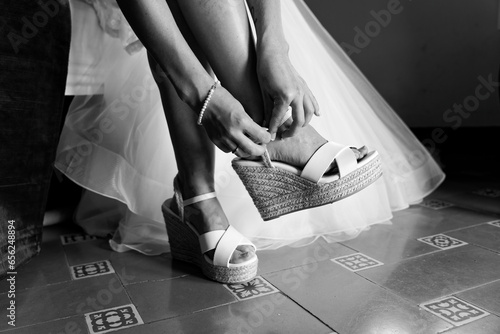 Novia poniendose los zapatos de la boda antes de ir al altar. photo
