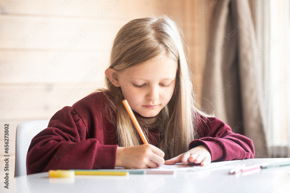 Girl draws with a pencil on paper, children's creativity Girl draws with a pencil on paper, children's creativity