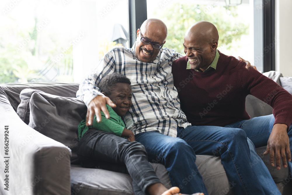 Happy african american father, son and grandfather sitting on couch,laughing and embracing Happy african american father, son and grandfather sitting on couch,laughing and embracing