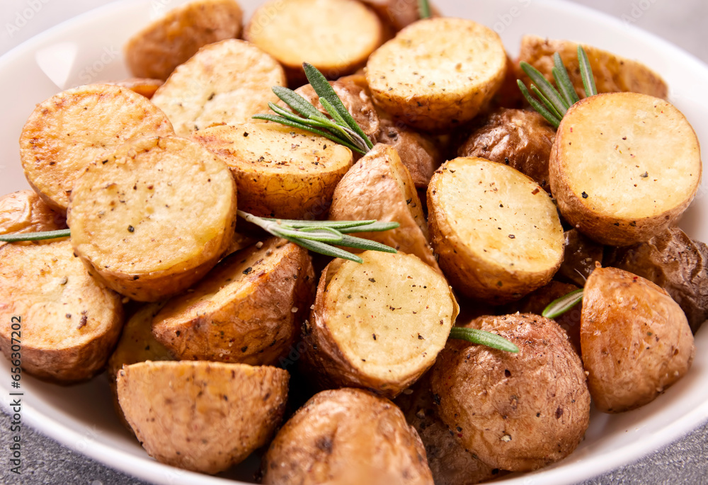 Delicious baked potatoes with rosemary on a gray background Delicious baked potatoes with rosemary on a gray background