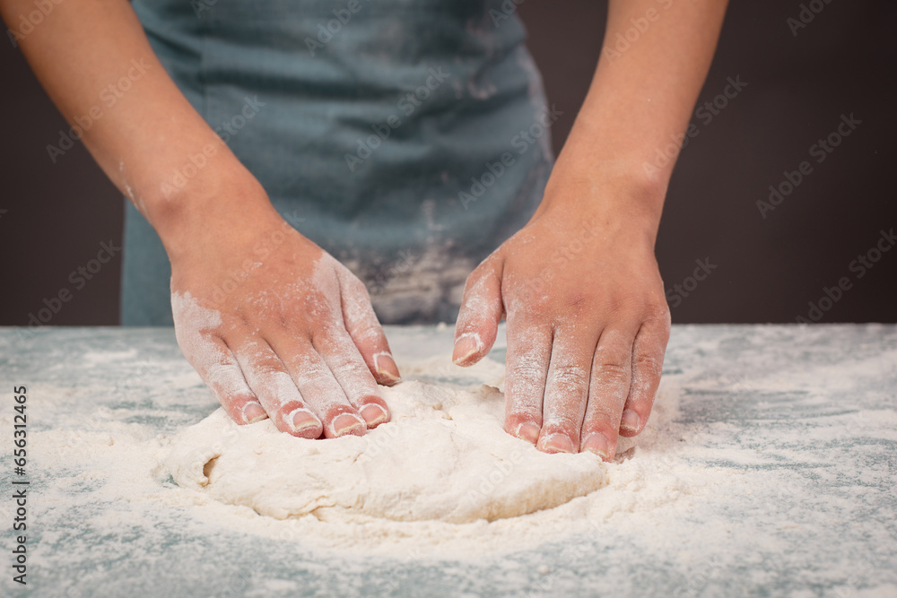 Baker kneading dough for pizza or artisan bread with his hands, prepare ingredients for food, baking pastry 