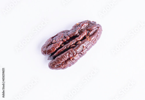 Roasted caramelized pecan nut on a white background, top view. Closeup