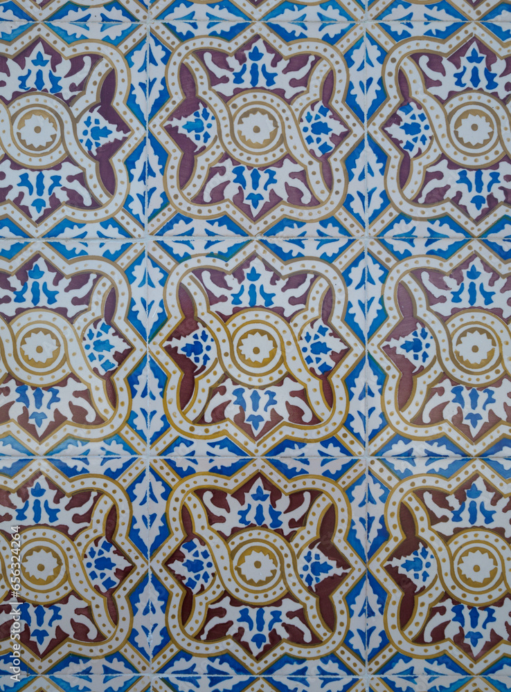 Part of a typical Portuguese wall decorated with tiles. Nice maroon, yellow, white and blue colors. Portugal. Vertical photo.