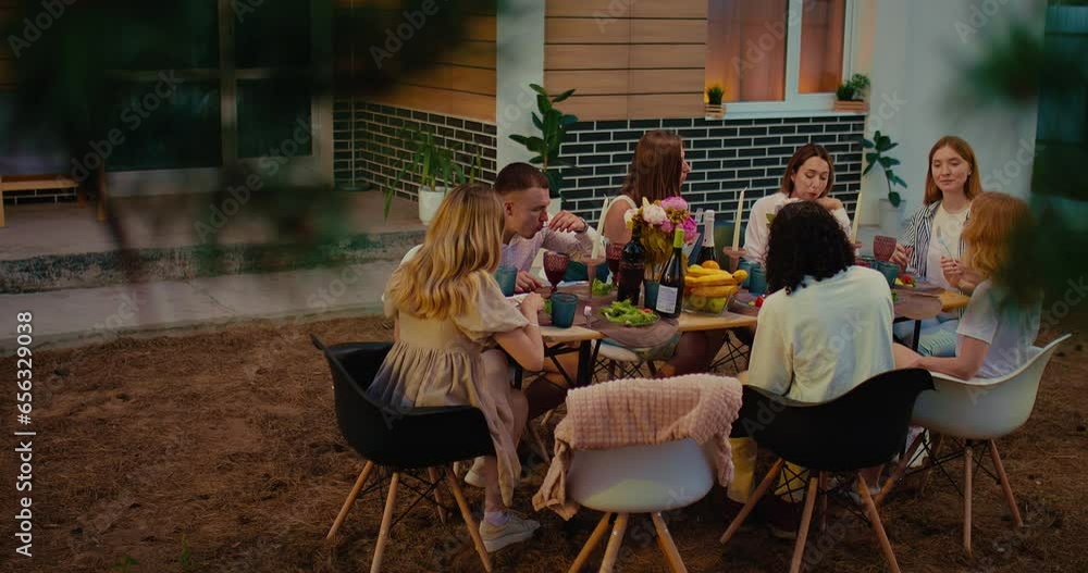 Group of multiethnic people dinning in patio in summer evening, friends party in backyard, 4K Prores Group of multiethnic people dinning in patio in summer evening, friends party in backyard, 4K Prores