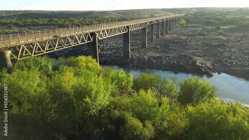 Jib up reveals metal structure of Old Wagon Bridge spanning across vast Orange River floodplain photo