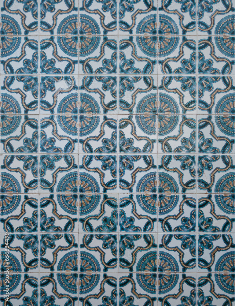 Part of a typical Portuguese wall decorated with tiles. Nice orange, blue and white colors. Portugal. Vertical photo.