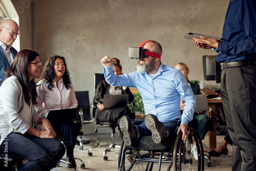Male and female colleagues looking at businessman with disability watching VR at creative office photo