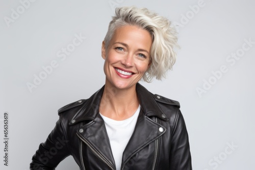 Portrait of a beautiful middle aged woman in leather jacket smiling at the camera. photo