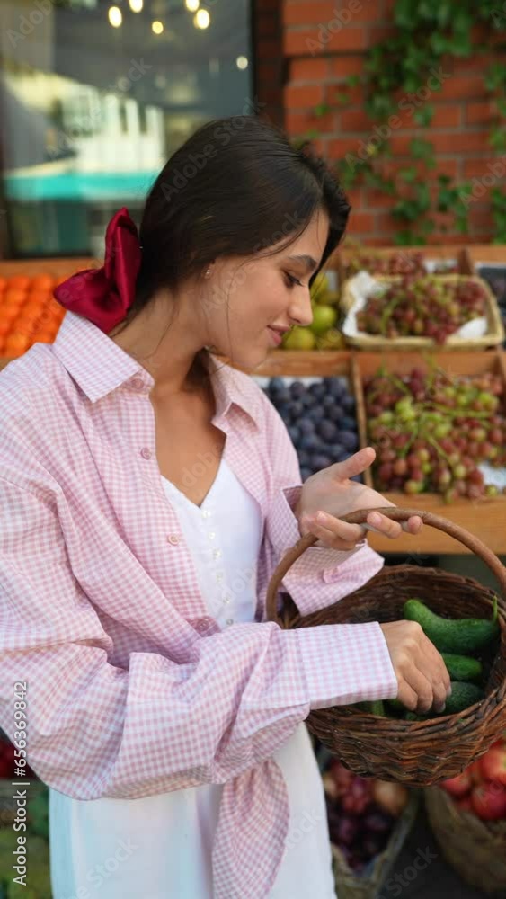 A beautiful young woman carefully places vegetables into a basket at the European farmer's market. A beautiful young woman carefully places vegetables into a basket at the European farmer's market.