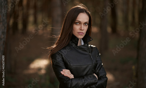 woman is wearing black leather jacket in the autumn park