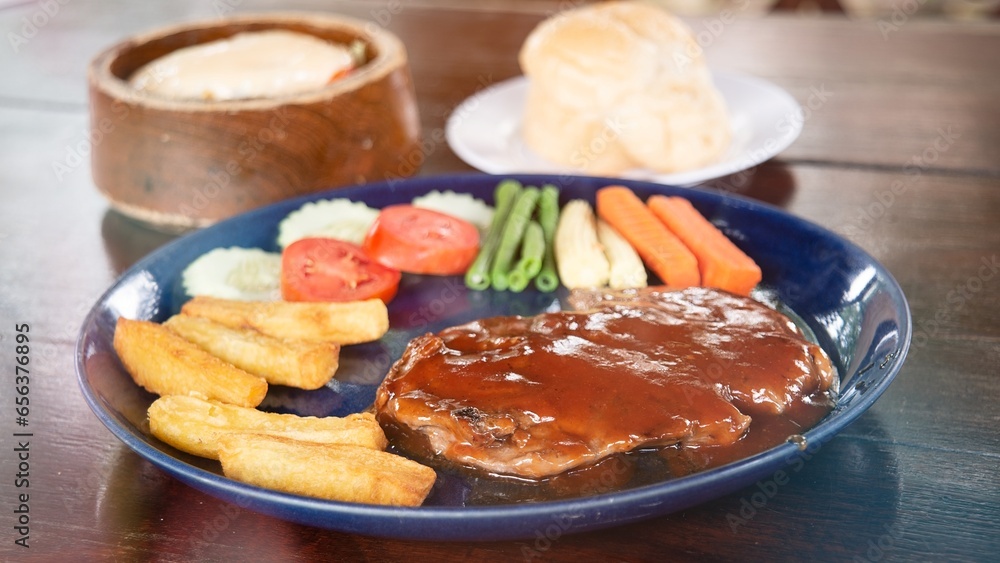 A juicy steak with tomato sauce drizzled over the beef was served on a plate with bread and salad A juicy steak with tomato sauce drizzled over the beef was served on a plate with bread and salad