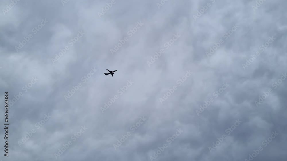 A plane flying against a cloudy gray sky. The concept of transport, travel, flight and tourism. A plane flying against a cloudy gray sky. The concept of transport, travel, flight and tourism.